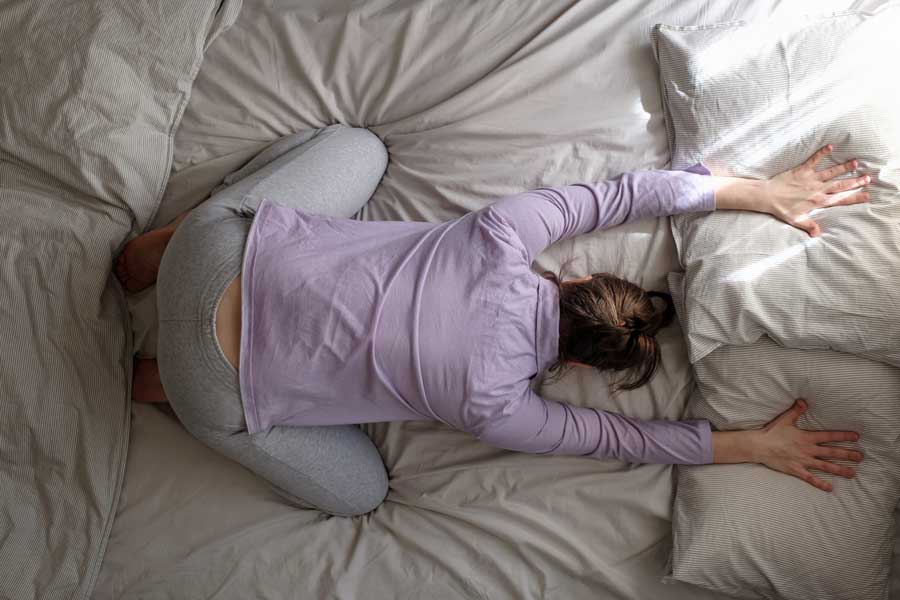 Mujer embarazada practicando Yoga Postura del Niño o Balasana