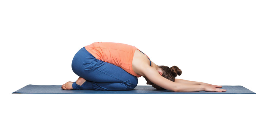 Mujer practicando Yoga Balasana o Postura del niño con brazos hacia adelante