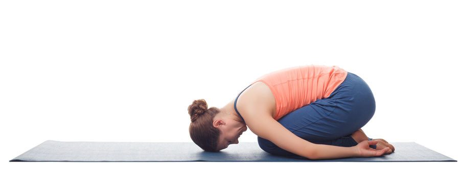 Mujer practicando Yoga Balasana o Postura del niño con brazos hacia atrás